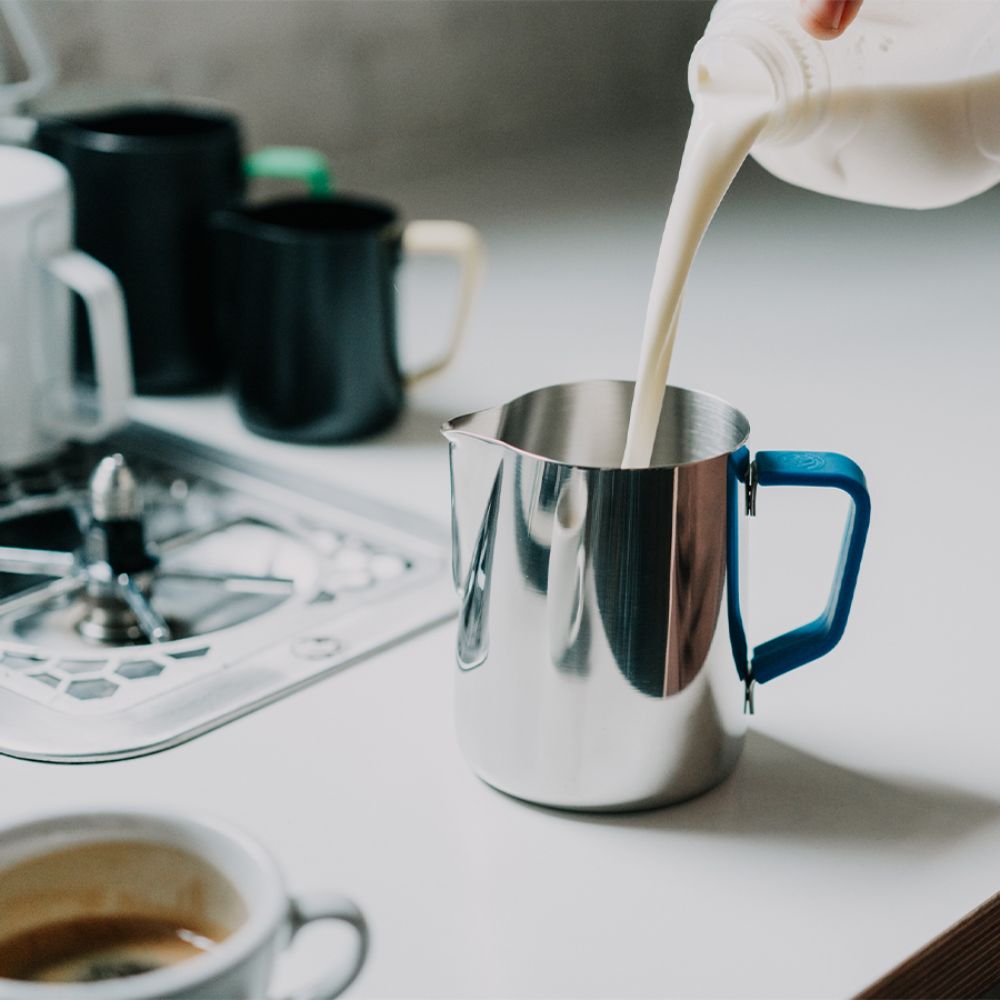 Koude melk in melkkan schenken